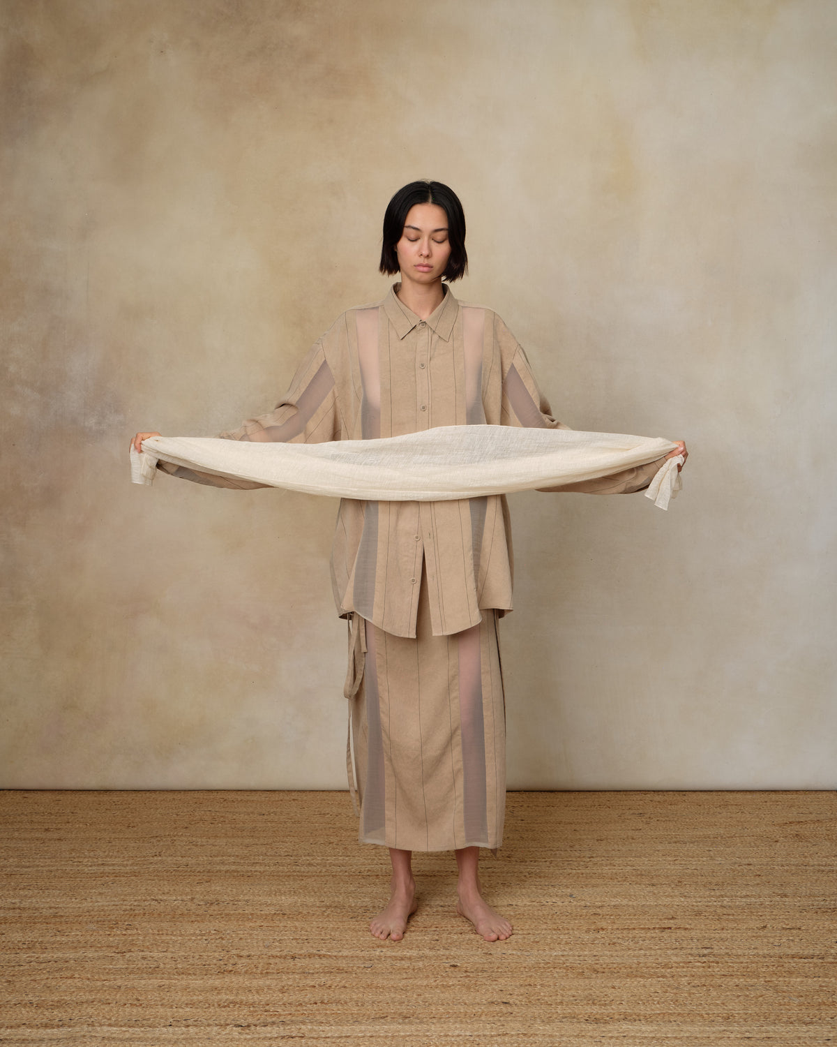 Colbo Scarf in natural linen-cotton mesh, held open by a model