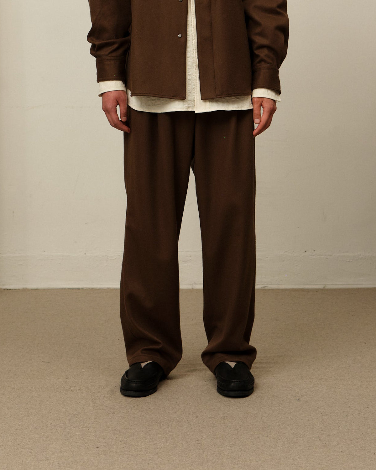 Model wearing double pleat pants in Brown.