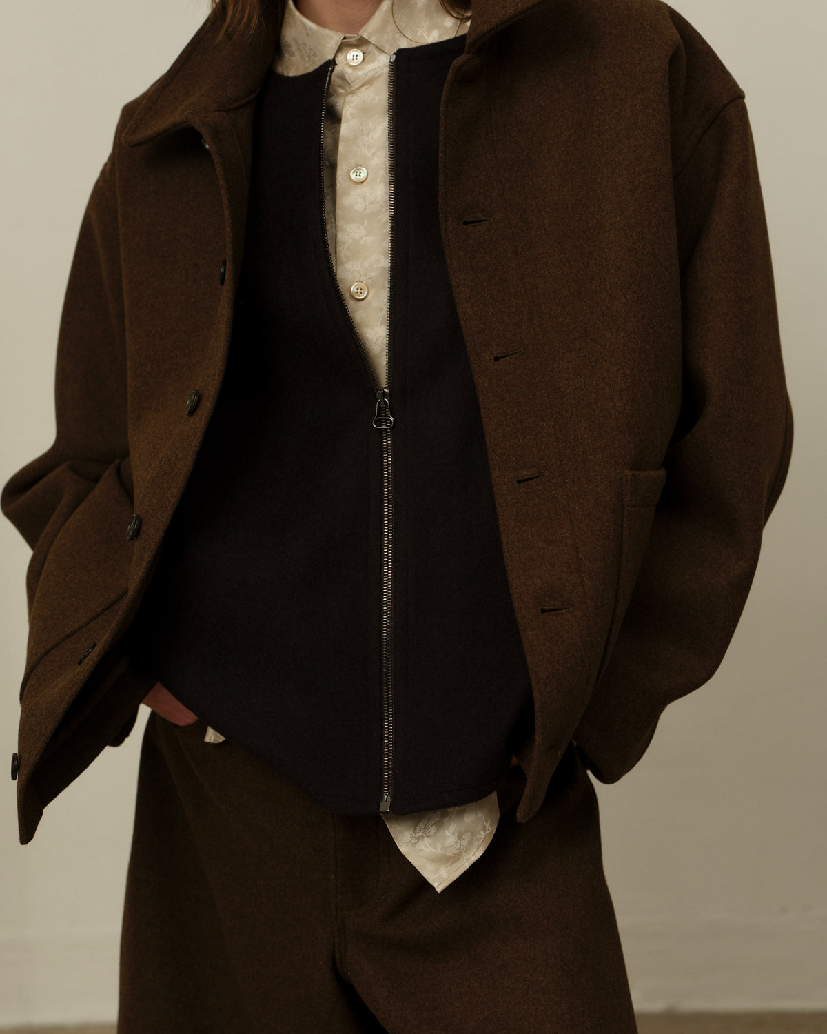 Colbo Steam Jacket in brown on model, open over a zip vest, detail