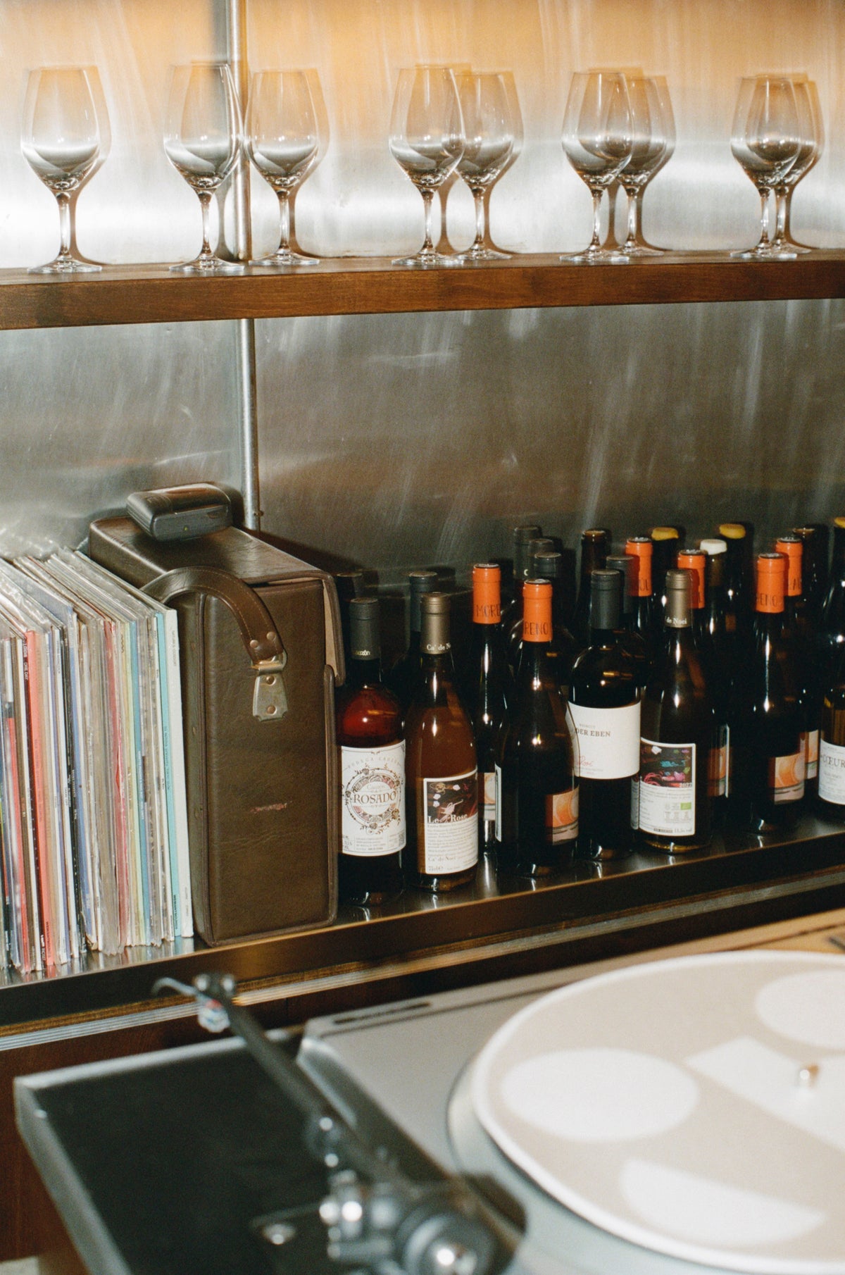 Wine bottles and records on the back shelf at Colbo Next Door