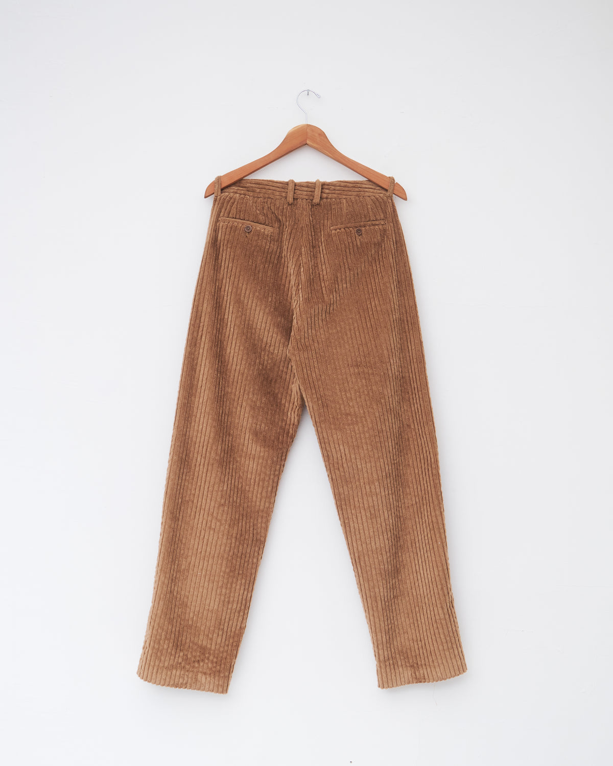 Colbo Wide Cord Chinos in dark tan wide-wale corduroy, back, on a hanger