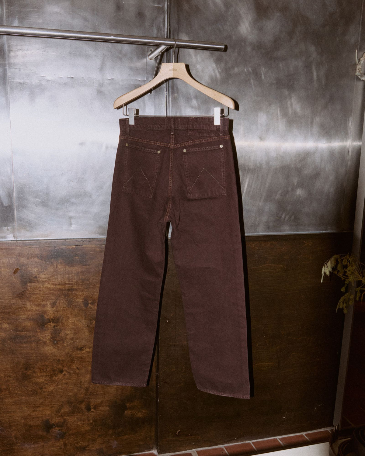 Carson Wach 333 Original Jeans in Colbo exclusive brown wash on a wooden hanger, back view