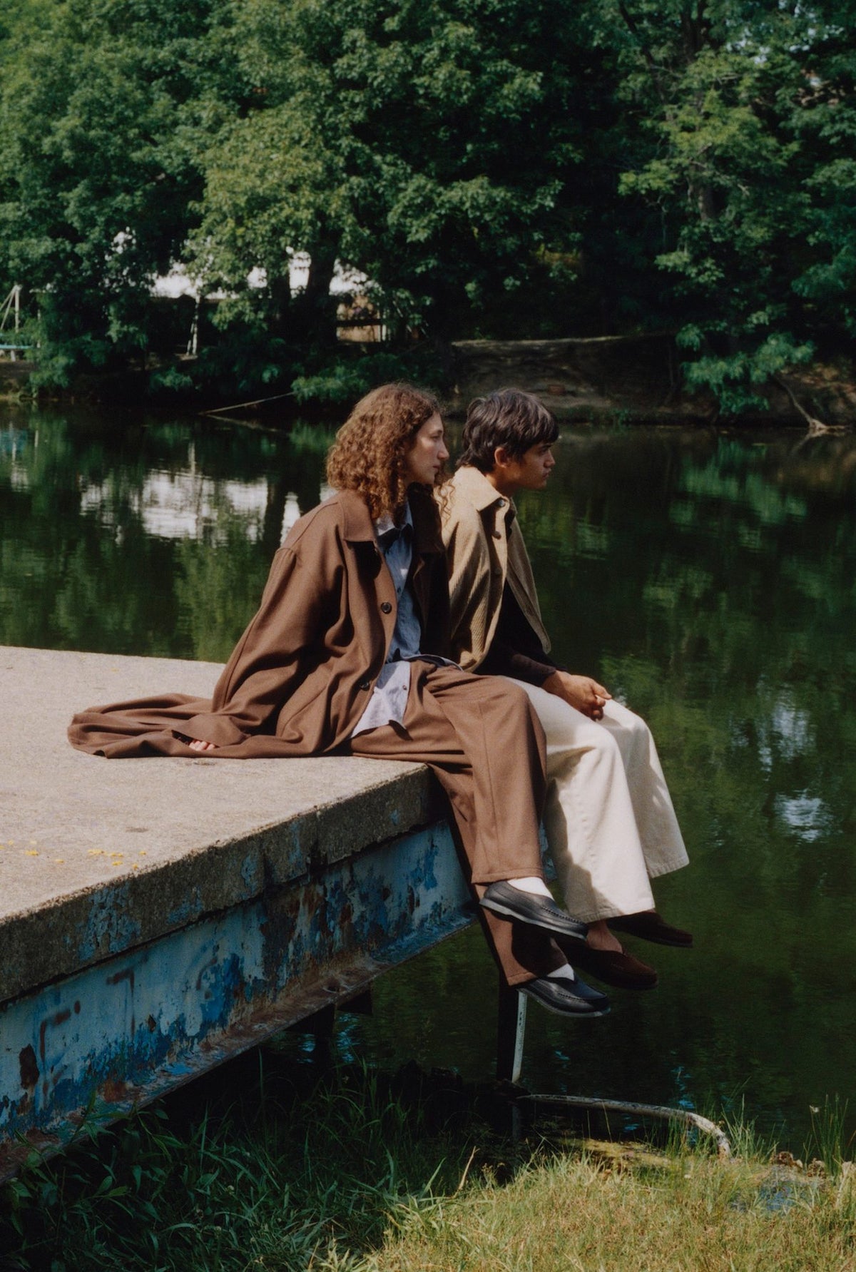 Two models on a dock by a pond, one in the Colbo Overshirt in Beige Washed Corduroy and Big Pocket Denim in Beige
