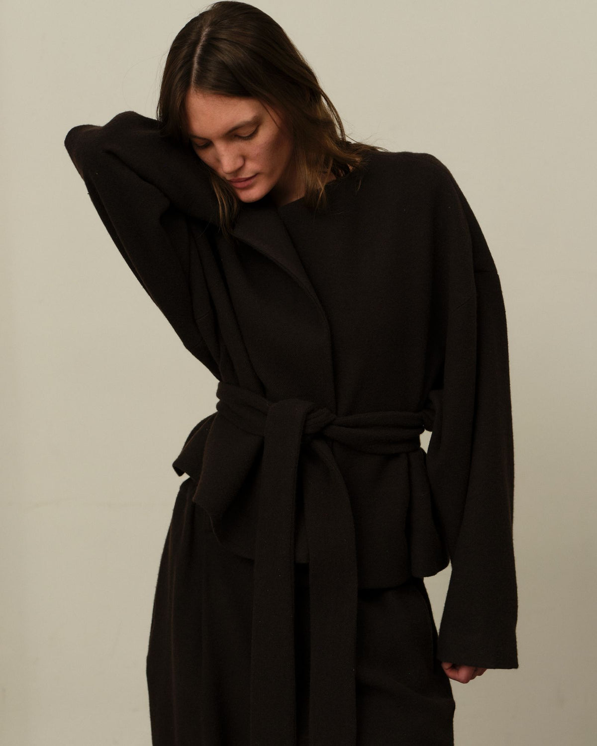 A model in the belted Colbo Omi Jacket and Camp Pants in Dark Plum