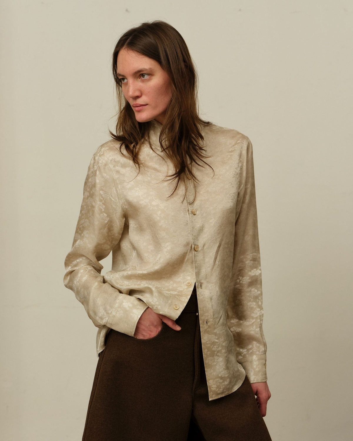 A model in the Colbo Bat Shirt in Floral jacquard with brown wool trousers