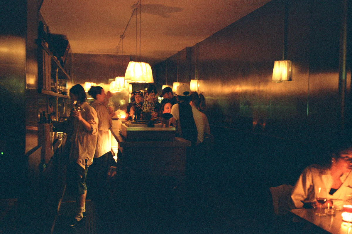 Next Door at night, the long bar under paper lamps and full of people