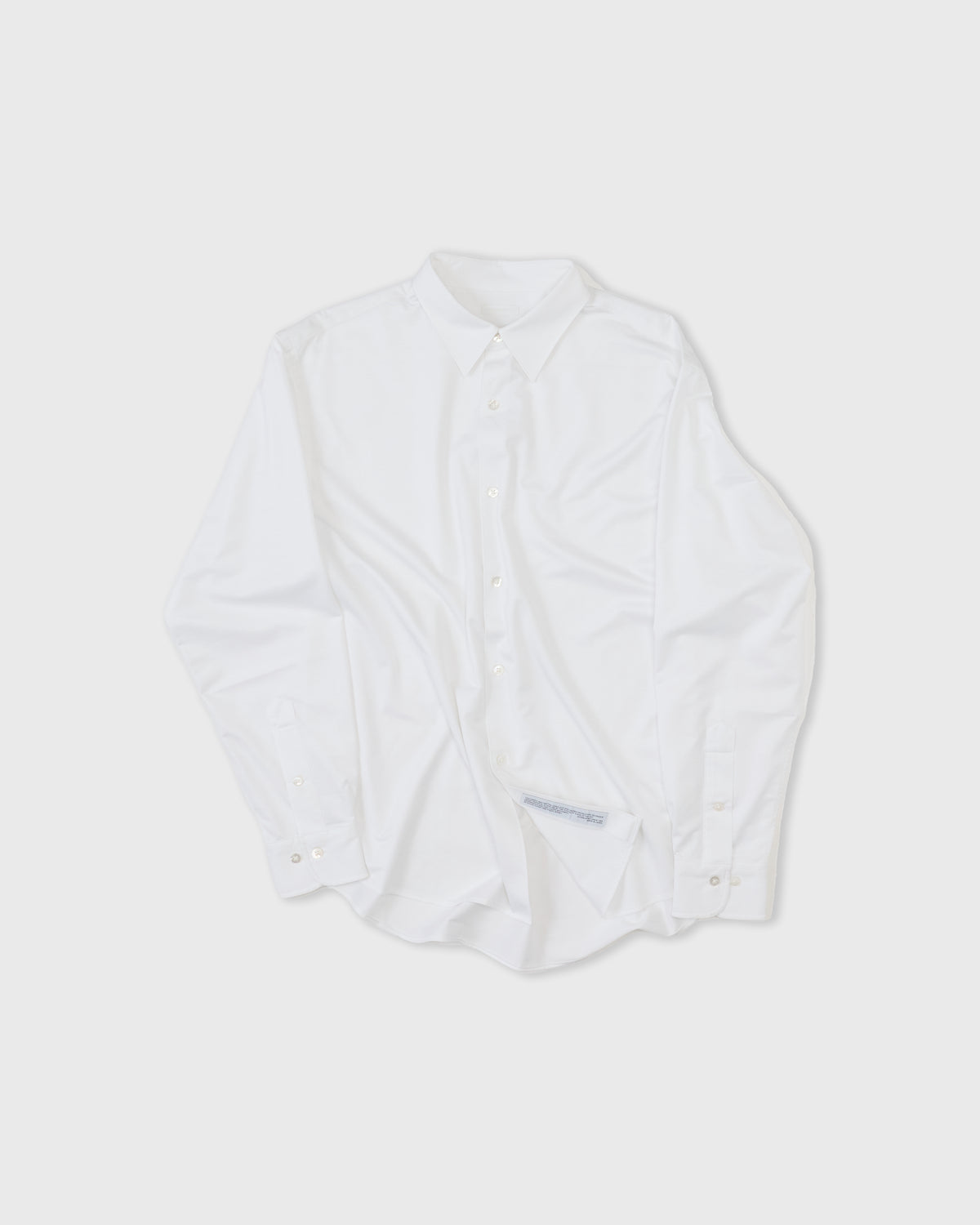 Kanemasa Phil Modest Shirt in white cotton-nylon, front, rumpled flat lay with care label showing