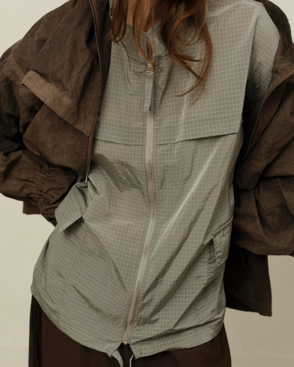 Colbo Track Jacket in sage grid, on model, layered under the Mel Jacket