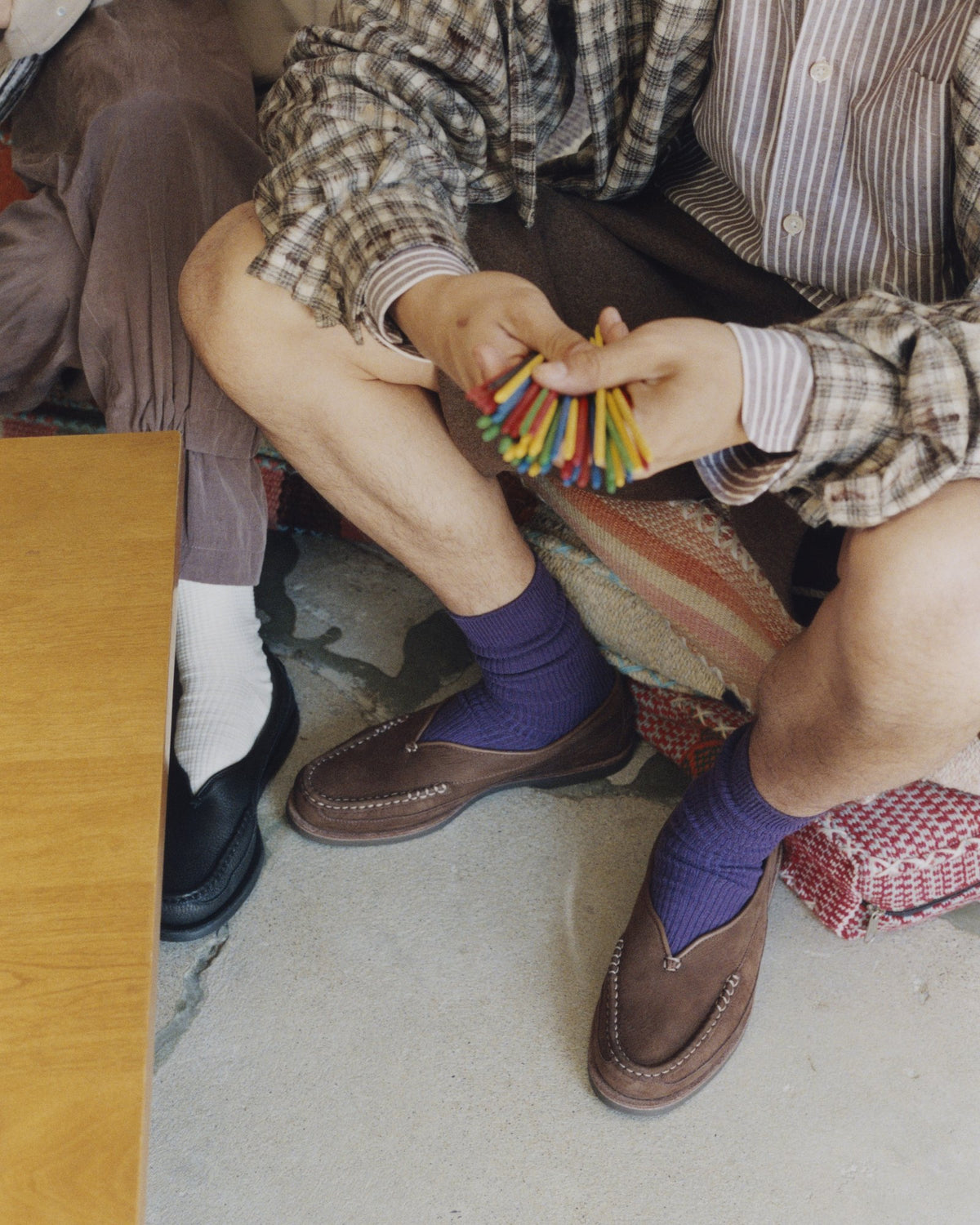 Chocolate Sirah loafers worn with purple socks and a plaid shirt