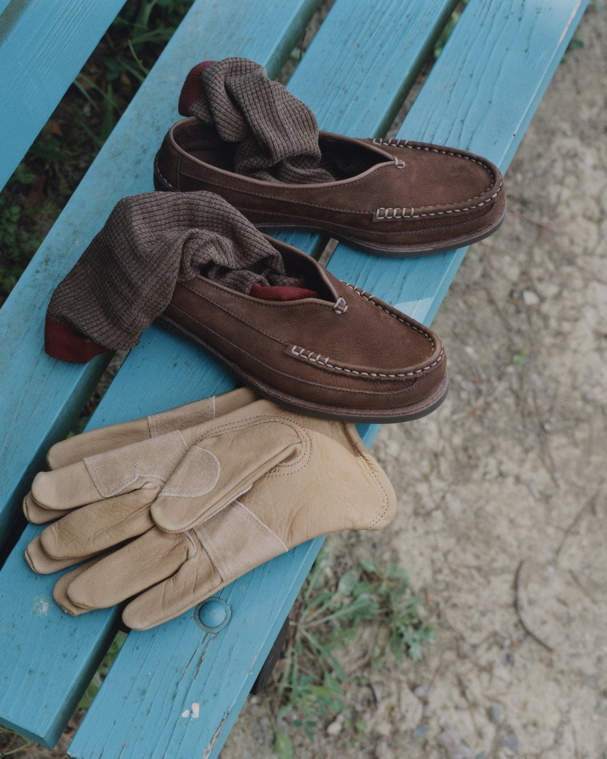 Chocolate nubuck Sirah loafers and suede gloves on a blue bench